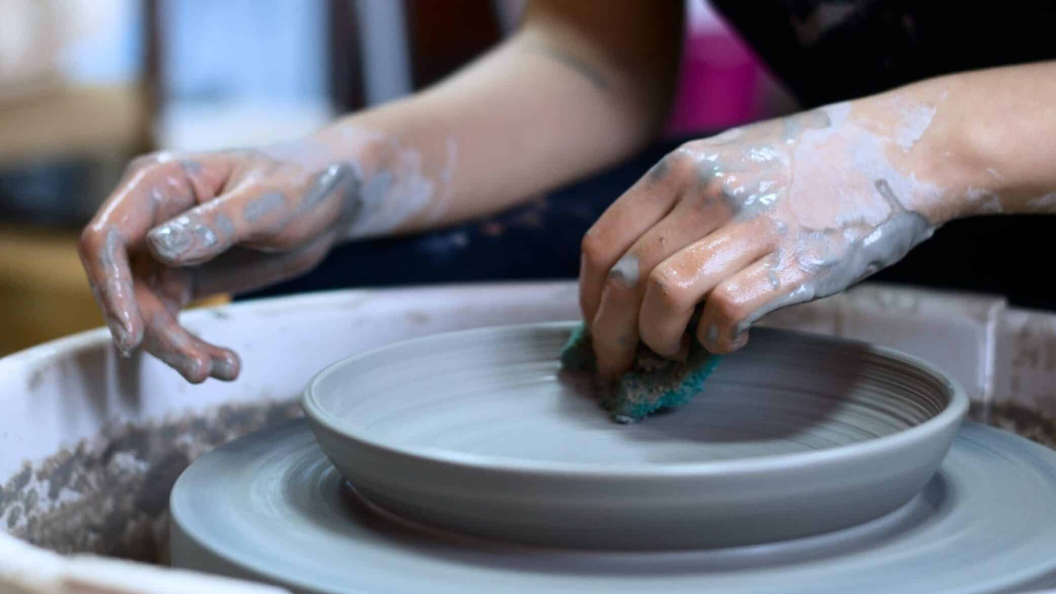 woman creating plate on wheel